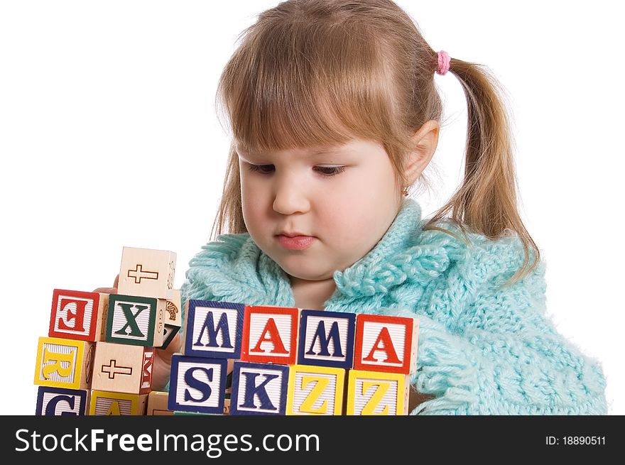 The little girl plays cubes on white