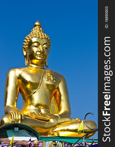 The smiling golden buddha statue under the open sky. The smiling golden buddha statue under the open sky