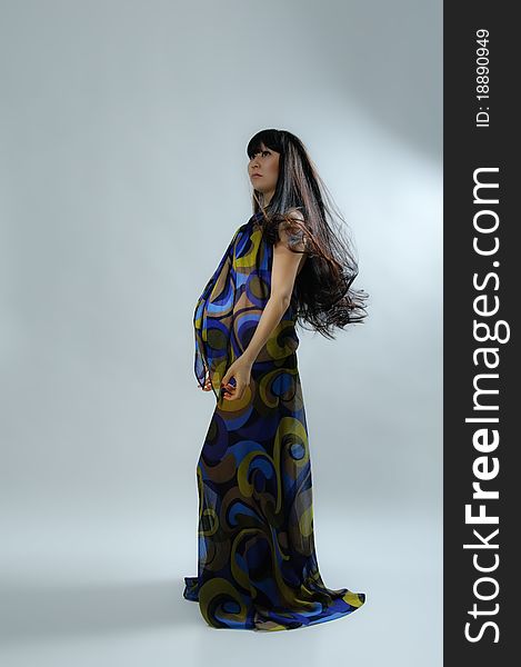 Asian pregnant woman in transparent dress on grey. Asian pregnant woman in transparent dress on grey