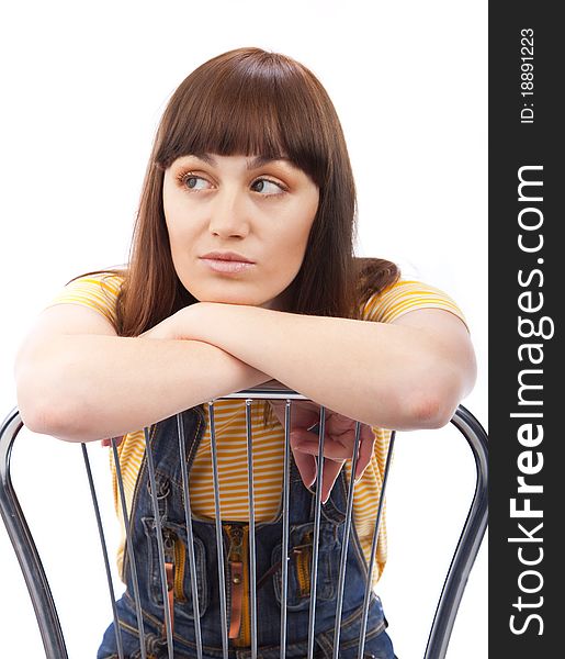 Positive adult woman sitting on a chair on a white background isolated