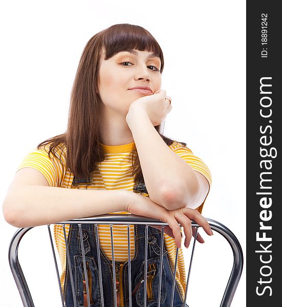 Positive adult woman sitting on a chair on a white background isolated