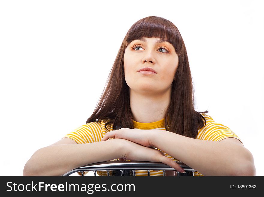 Positive adult woman sitting on a chair on a white background isolated