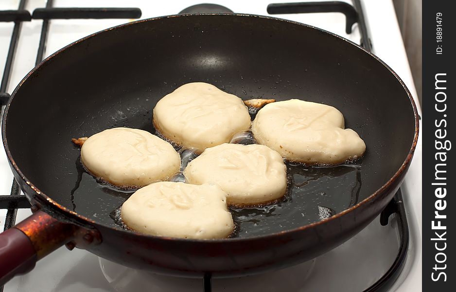 Raw pancakes are fried in a pan