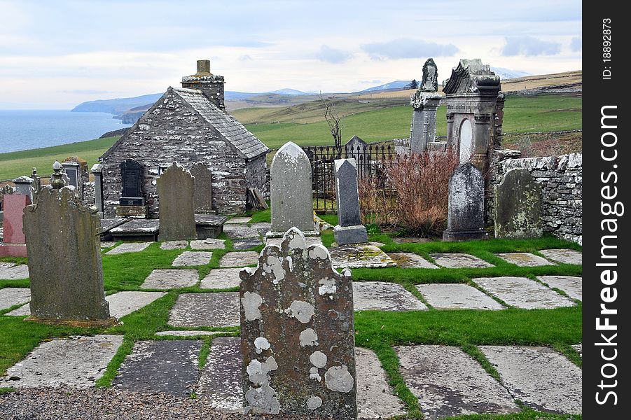 Latheron is on the A9, Latheron Graveyard, Caithness, Scotland, UK Latheron &#x28;Scottish Gaelic: Latharan&#x29; is a small village and civil parish in Caithness, in the Highland Region of Scotland, centred on the junction of the A9 with the A99. Latheron Parish Churchyard is at Wheel, near the road from Latheron to Lybster. It has been extended to the East. The old parish church built in 1734 is now home to the Clan Gunn Museum opened in 1985. An 18th-century parish church, and a fragment of its predecessor, apparently occupying the site of a 13th-century church. Latheron was one of the churches reserved to the bishop in a charter of 1223 x 45, and in 1515 the vicar of Latheron is on record but intermediate references appear to be lacking. A new church was built about 1734, part of its predecessor being retained in the rear to serve as a burial place of the Sinclairs of Dunbeath. Known as &#x27;The Aisle&#x27;, this fragment presents no features of architectural interest, although a 17th-century monument with an effaced Latin inscription is built into the wall. No stones of interest are visible in the churchyard. A belfry was added to the church in 1822 in which the bell from the 17th-century bell tower &#x28;ND23SW 5&#x29; was installed.