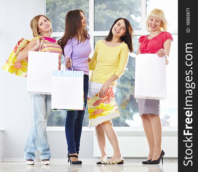 Happy young adults standing in mall with shopping bags. Happy young adults standing in mall with shopping bags