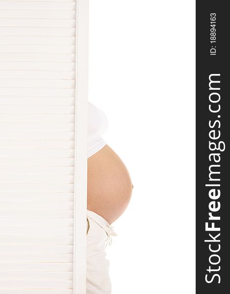 Belly pregnant woman leaned out from behind the door isolated on white
