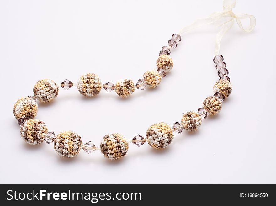 Necklace of beads knitted on a white background