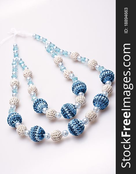 Necklace of beads knitted on a white background