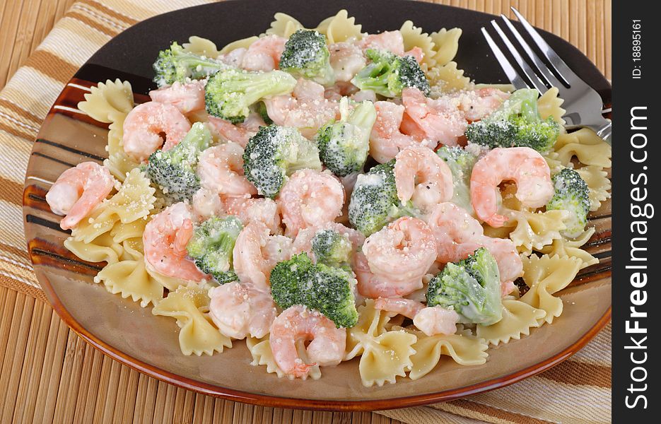 Shrimp and broccoli florets on top of pasta. Shrimp and broccoli florets on top of pasta