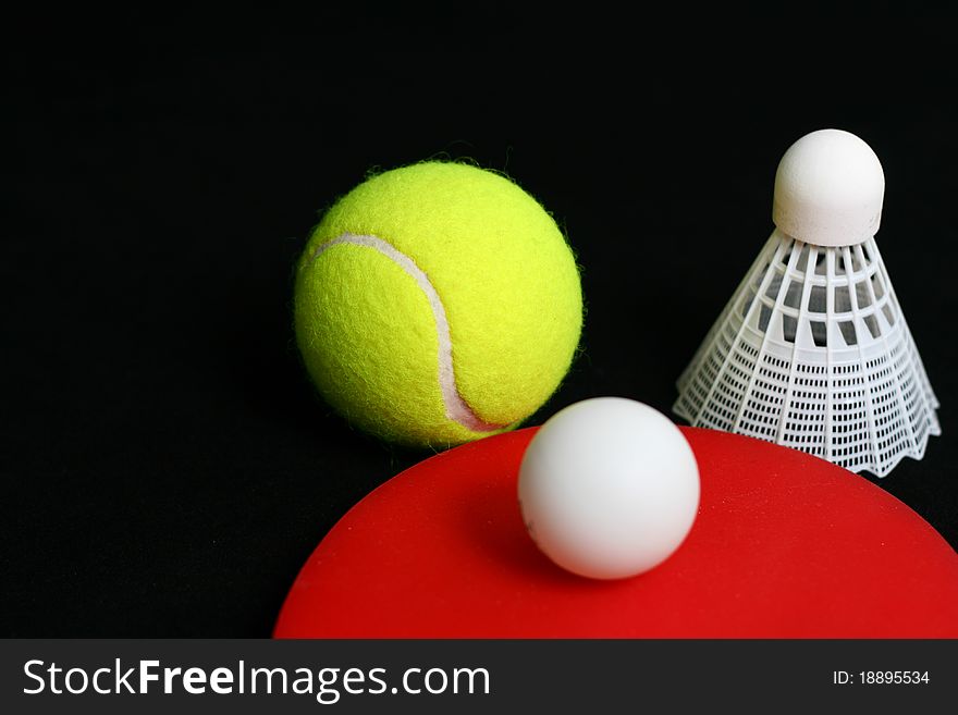 Tennis balls, shuttlecock isolated on black background. Tennis balls, shuttlecock isolated on black background