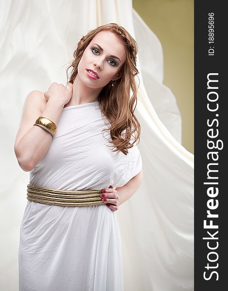 A studio portrait of a beautiful young woman, wearing a long, white, ancient greek inspired dress, surrounded by a flowy, wavy white fabric. A studio portrait of a beautiful young woman, wearing a long, white, ancient greek inspired dress, surrounded by a flowy, wavy white fabric.