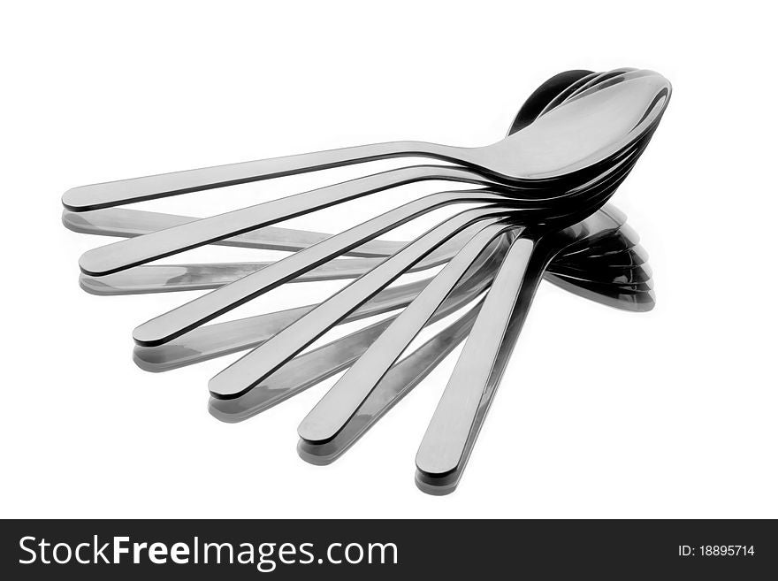 Six spoons spread as a fan on reflecting background