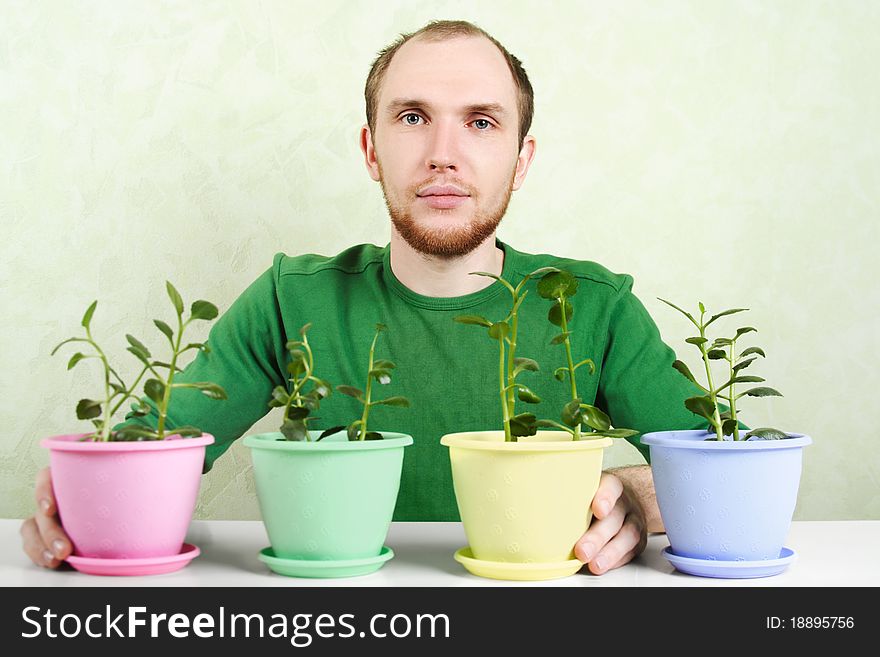 Man sitting near table with potted plants