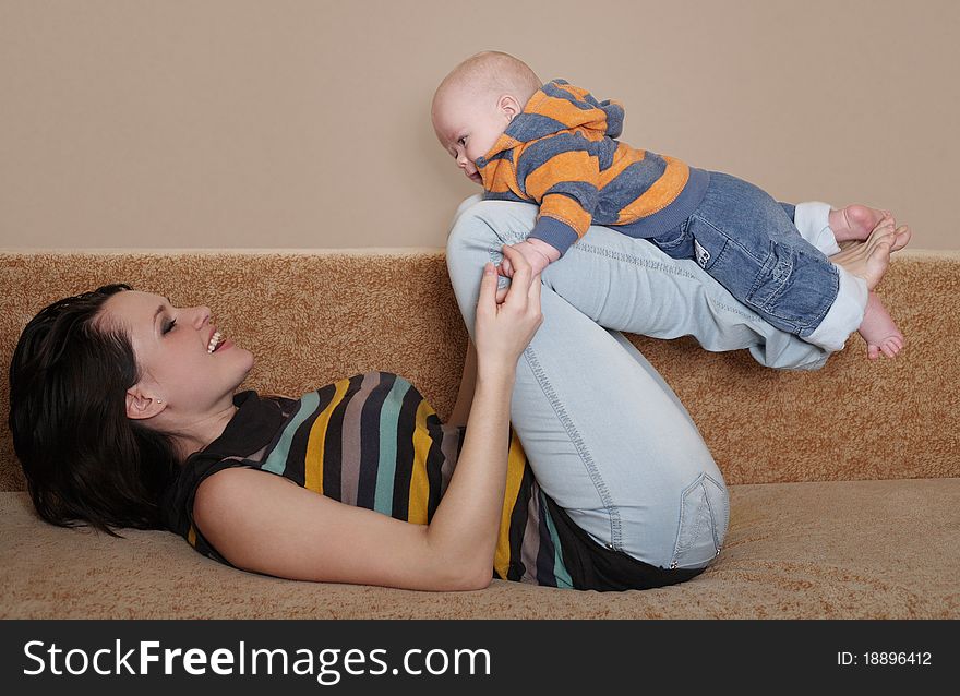 Young mum plays with the cheerful baby. Young mum plays with the cheerful baby