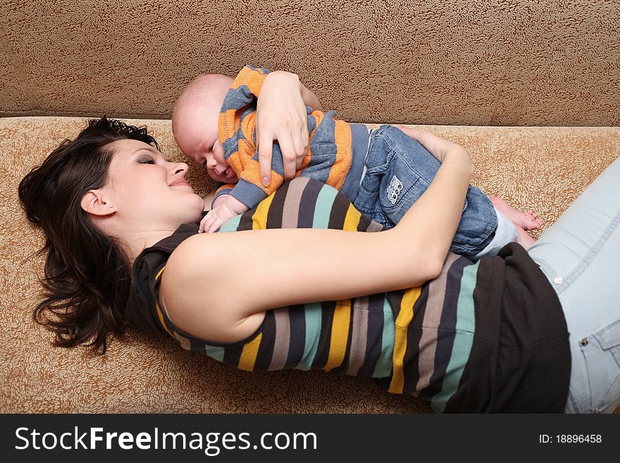 Young mum plays with the cheerful baby. Young mum plays with the cheerful baby