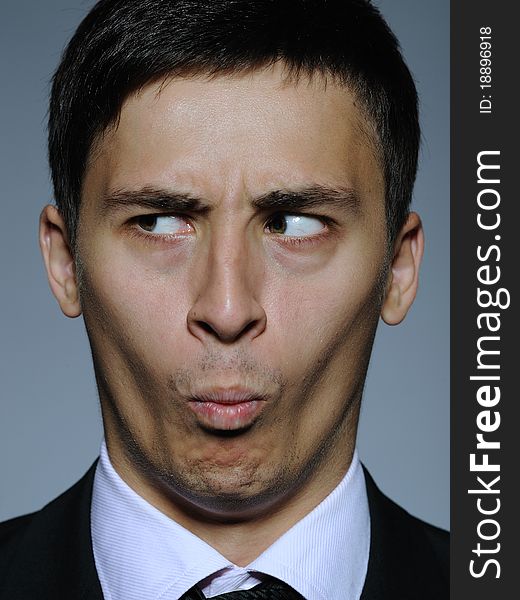 Portrait of funny surprised business man in formal suit and black tie . expressions on gray background. Portrait of funny surprised business man in formal suit and black tie . expressions on gray background