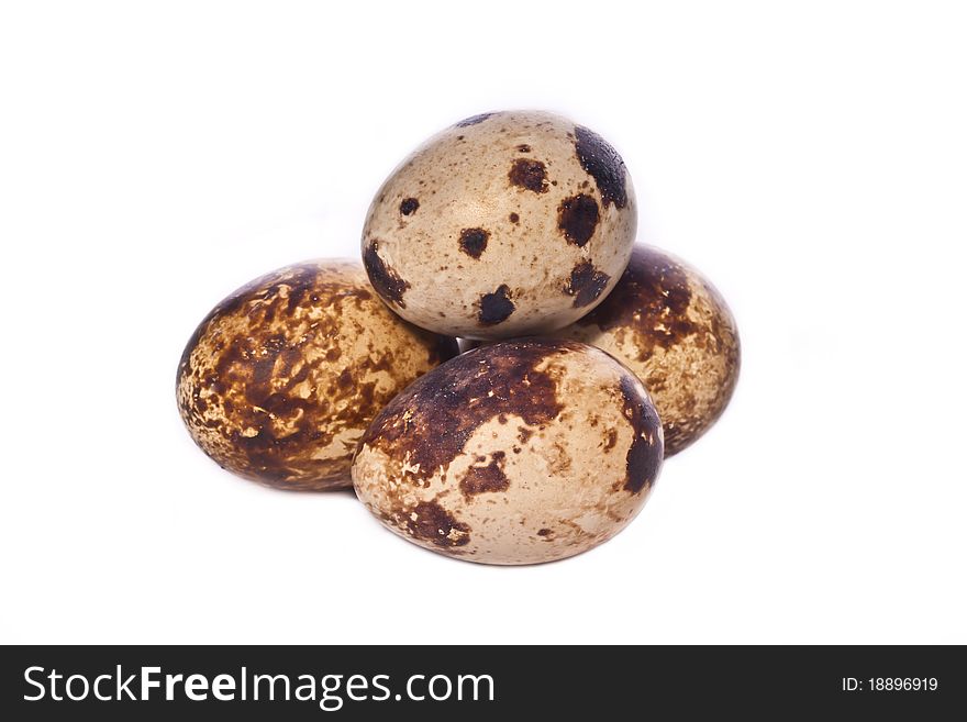 Four quail eggs across white