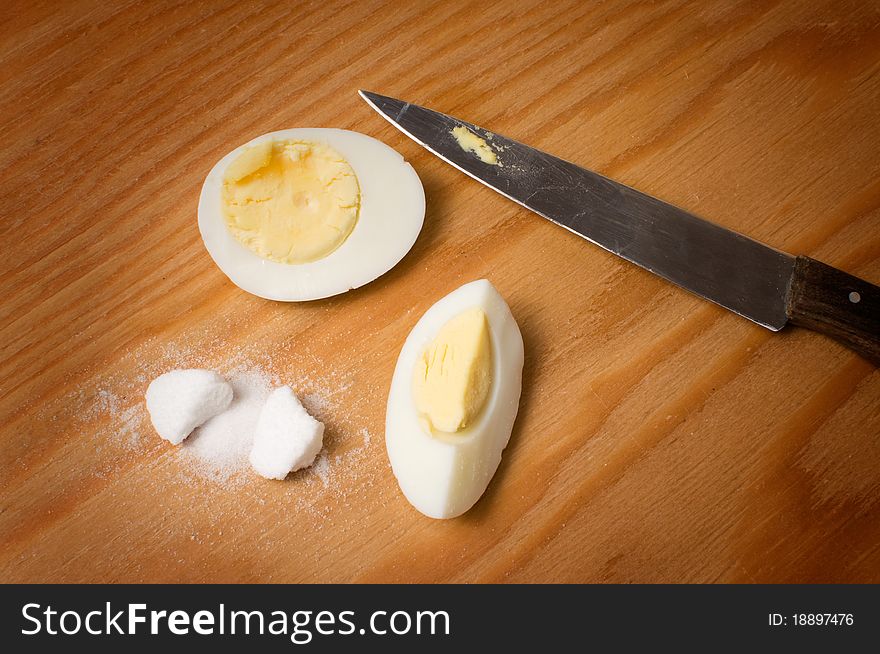 Eggs, salt and knife on a board