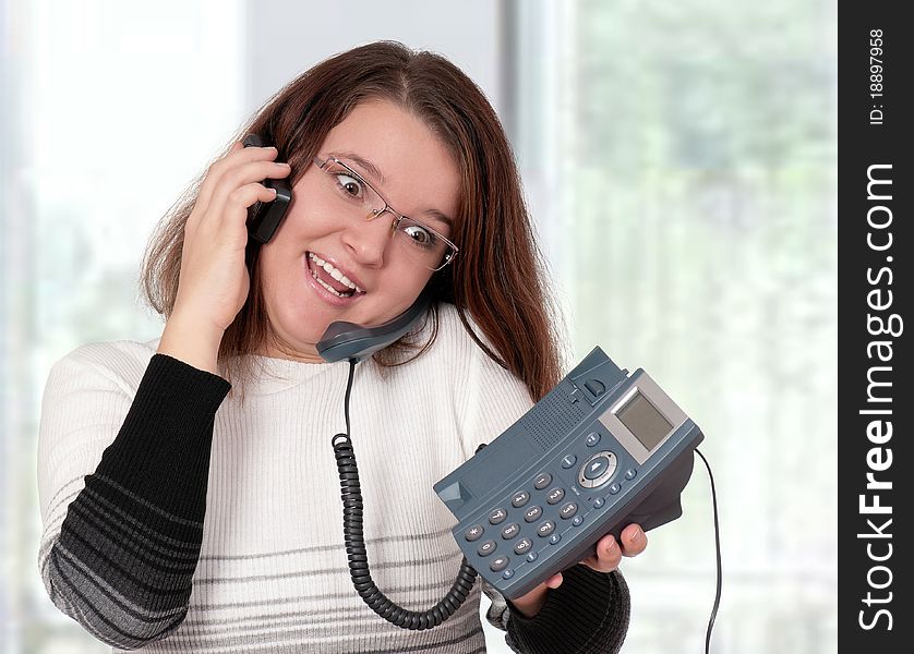 Beautiful businesswoman working with two phone at her office. Beautiful businesswoman working with two phone at her office