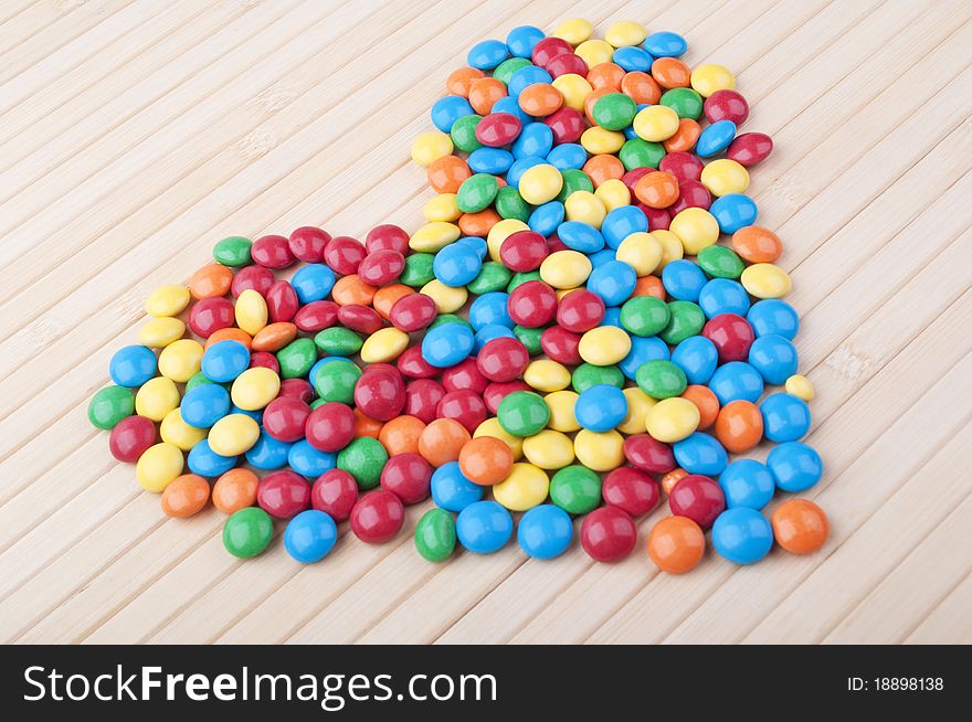 Many colored candy on a wooden table. Many colored candy on a wooden table