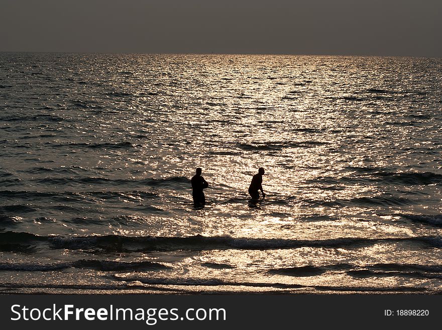 Silhouette of men in the sea at a beach. Silhouette of men in the sea at a beach.