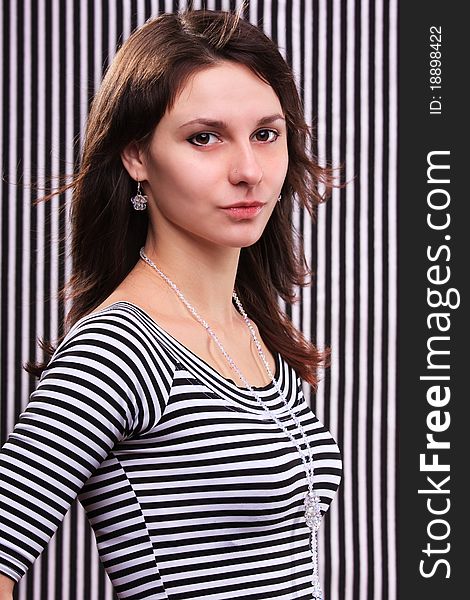 Cute girl in a striped blouse on the striped background
