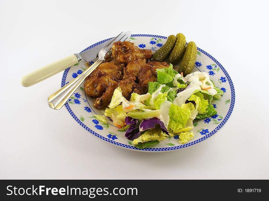 Chicken and salad meal with spoon and pork on the side