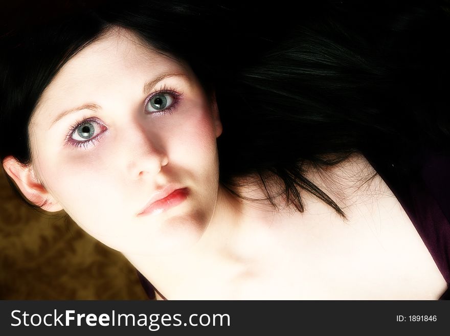 Close up of beautiful teen girl with long black hair and blue eyes.