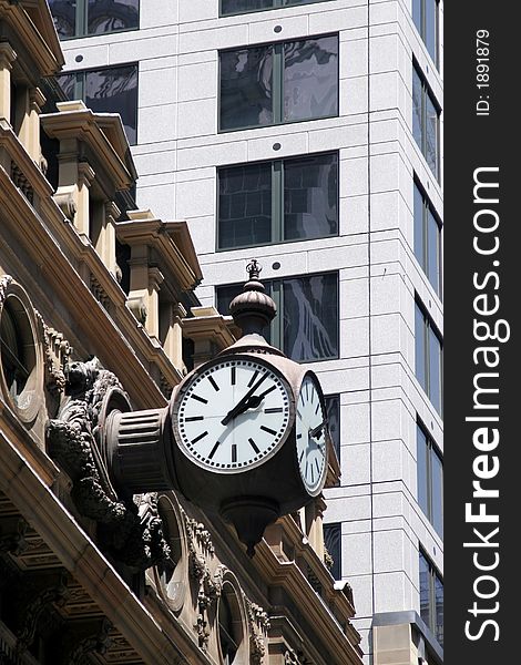 Vintage Clock Mounted On An Old Building Next To A Modern Office Building. Vintage Clock Mounted On An Old Building Next To A Modern Office Building