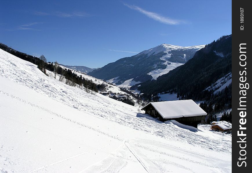 Mountain valley with chalet and snow