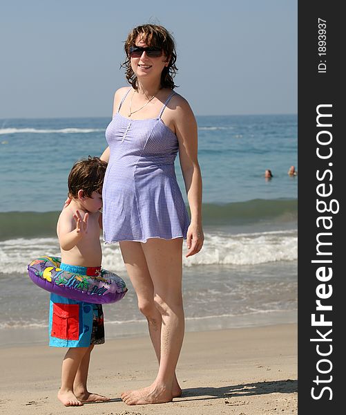 Pregnant woman with her son on the beach. Pregnant woman with her son on the beach