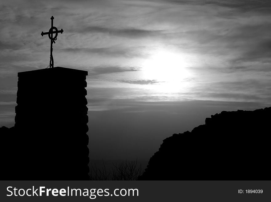 Cross by the sunset in old castle