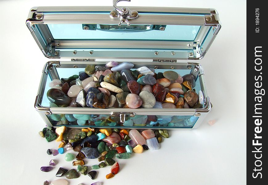 Gem stones in a clear blue treasure chest. Gem stones in a clear blue treasure chest