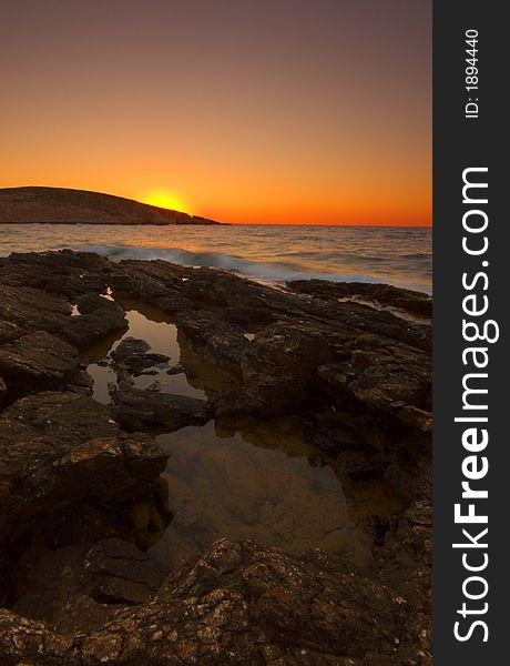 Sunset over rock greek coast. Sunset over rock greek coast