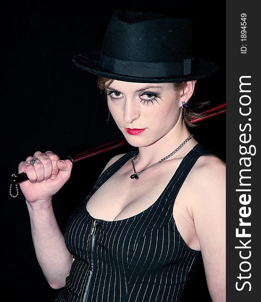 Woman with a riding crop making a come hither gesture.and a serious expression. Woman with a riding crop making a come hither gesture.and a serious expression.