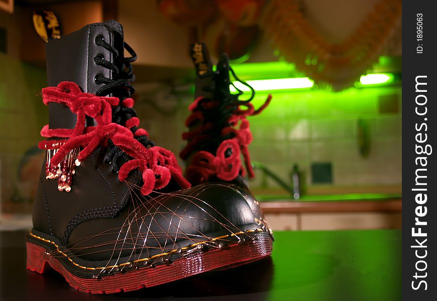 A pair of black boots redecorated for party with wire and red ties. A pair of black boots redecorated for party with wire and red ties