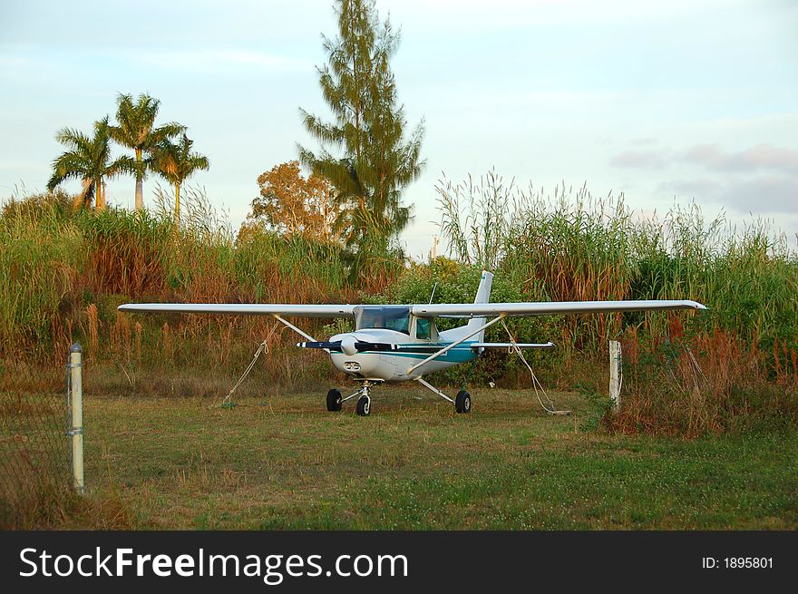 Remote airstrip with light airplane parked. Remote airstrip with light airplane parked