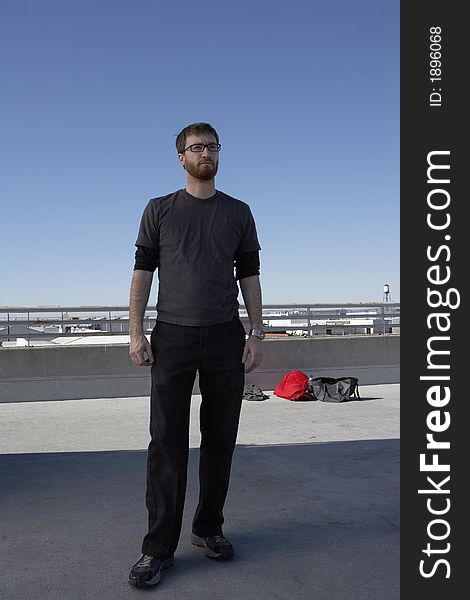 Full length picture of a man standing on top a roof. Full length picture of a man standing on top a roof.