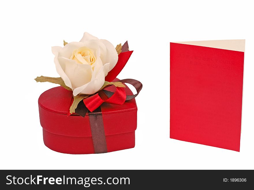 Heart shape red chocolate box with rose and a red card isolated over white background. Heart shape red chocolate box with rose and a red card isolated over white background