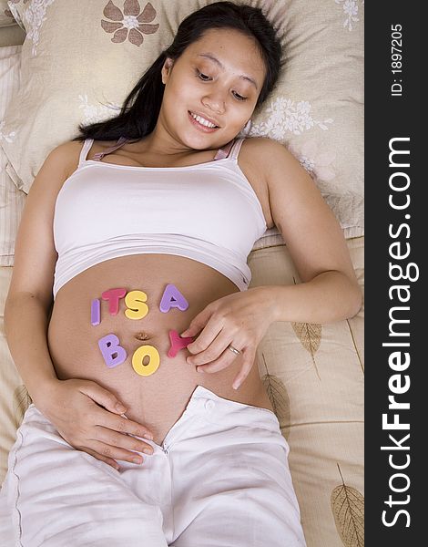 Pregnant woman playing with letters on her belly. Pregnant woman playing with letters on her belly