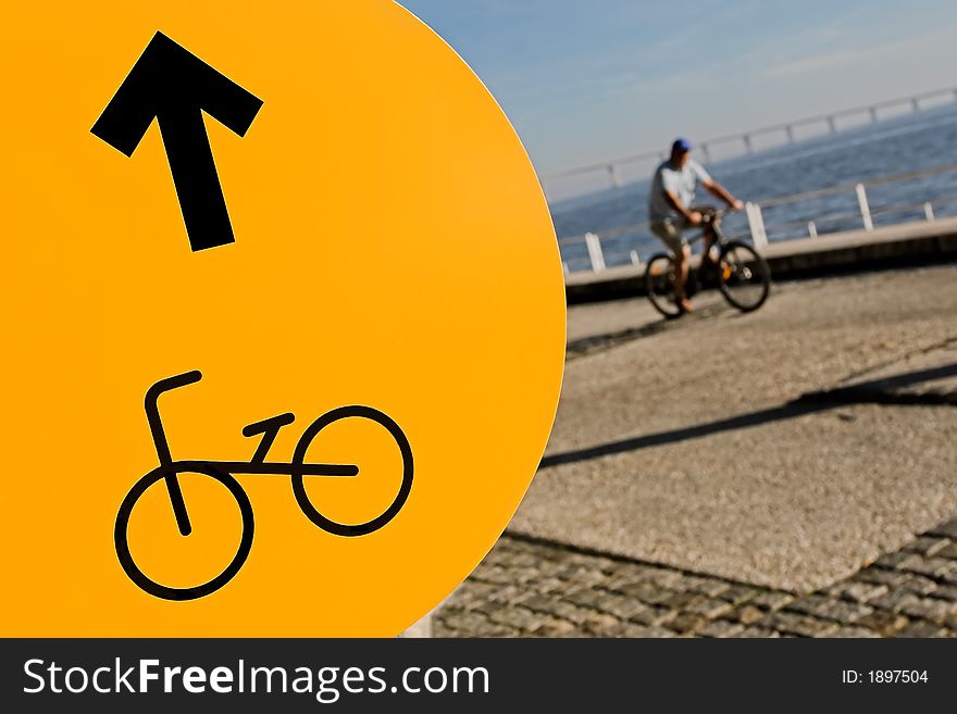 Yellow cycleway sign and a blurred cycler. Yellow cycleway sign and a blurred cycler