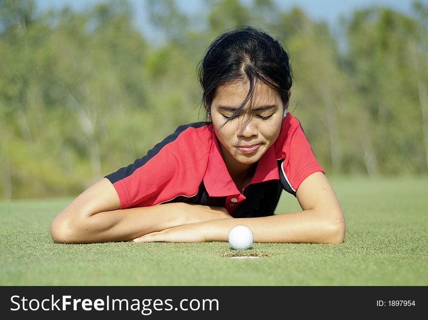 Young, female golf player and a golf ball that almost made it. Young, female golf player and a golf ball that almost made it.