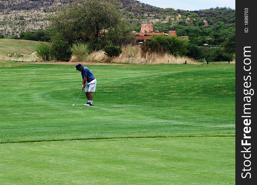 Golfer preparing to hit the ball onto the green. Golfer preparing to hit the ball onto the green.