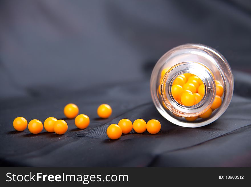 Round yellow vitamins and bank on a blue background