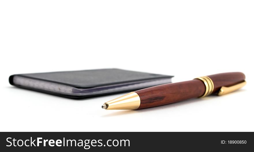 Detailed close up of the handle lying near to a notebook. Detailed close up of the handle lying near to a notebook