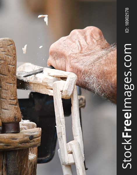 Carpenter carving a wood chain in a traditional fair. Carpenter carving a wood chain in a traditional fair