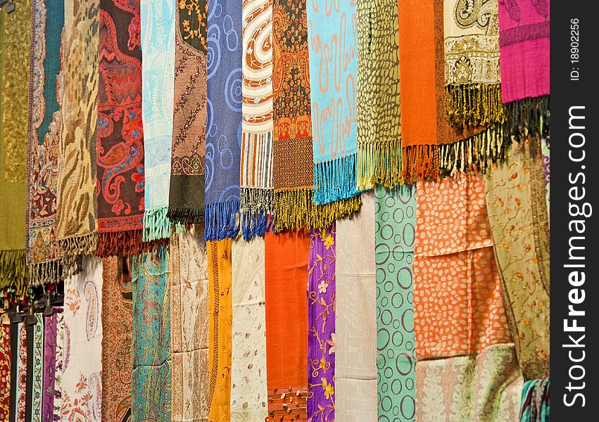 Rows of fabrics hanging at a market stall. Rows of fabrics hanging at a market stall