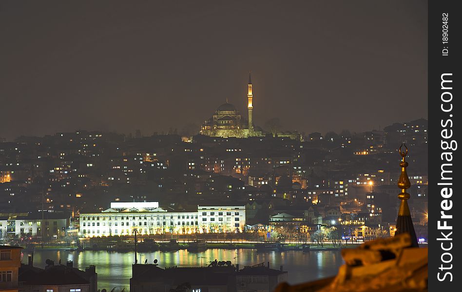 Cityscape at night with a large mosque