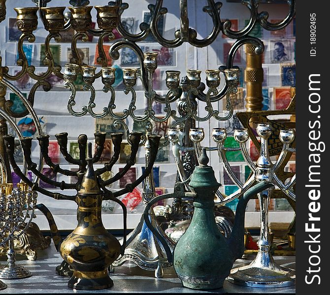 Background of the retro and antique traditional Jewish holiday candlesticks with vintage jugs and old albums of stamps. Jerusalem flea market. Background of the retro and antique traditional Jewish holiday candlesticks with vintage jugs and old albums of stamps. Jerusalem flea market.