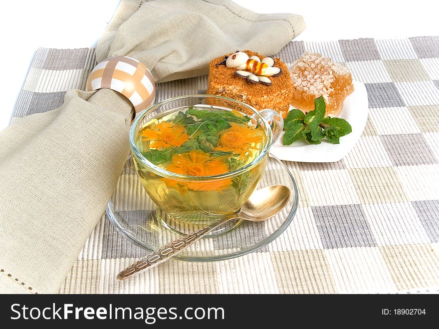 Herbal tea and cake on textile mat